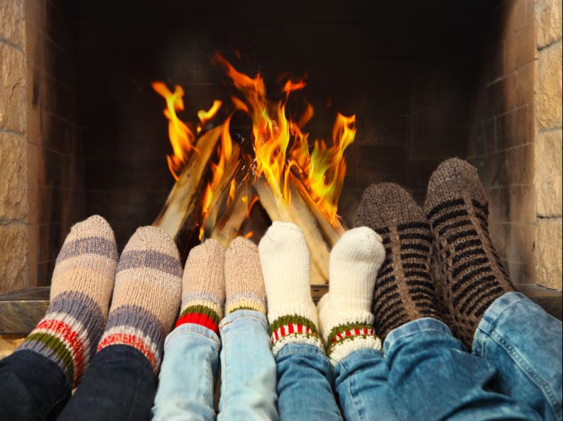 family feet warming on fireplace